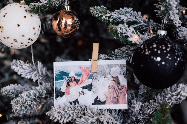 Schön geschmückter schneebedeckter Weihnachtsbaum mit Kugeln und Fotos