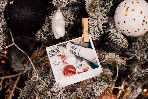 Schön geschmückter schneebedeckter Weihnachtsbaum mit Kugeln und Fotos