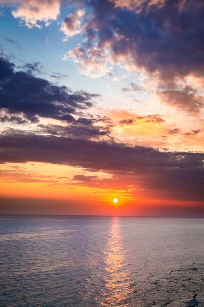 Schöne Abenddämmerung über ruhigem Meer im Sommer mit Sonnenstrahl