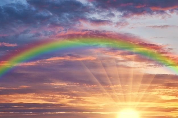 Foto schöne abendwolke des sonnenuntergangs mit einem regenbogen nach regen