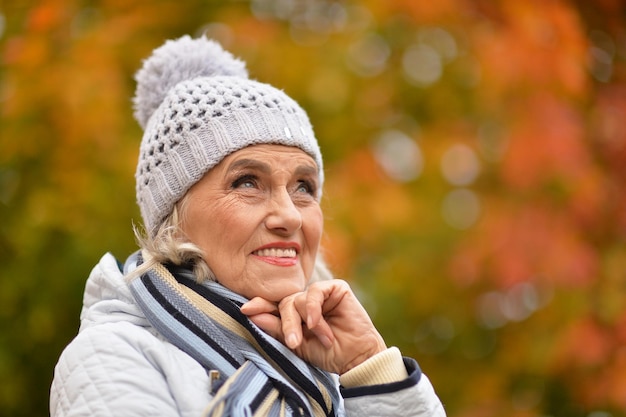 Schöne ältere Frau, die draußen im Herbst aufwirft