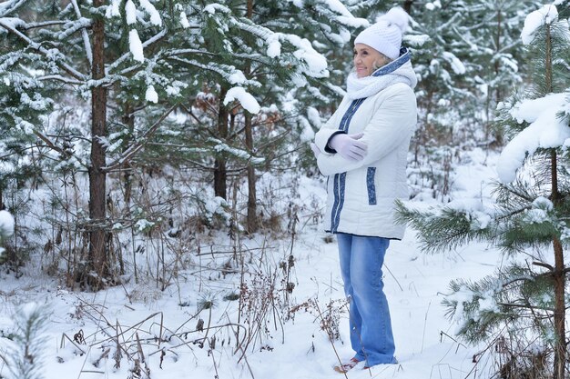 Schöne ältere Frau, die im Winter draußen aufwirft