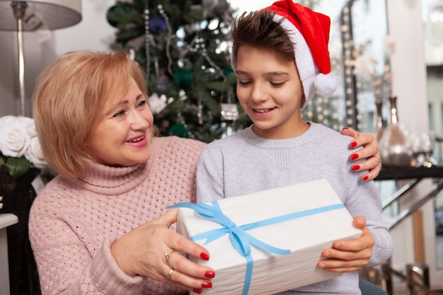 Schöne ältere Frau, die Weihnachten mit ihrem Enkel feiert