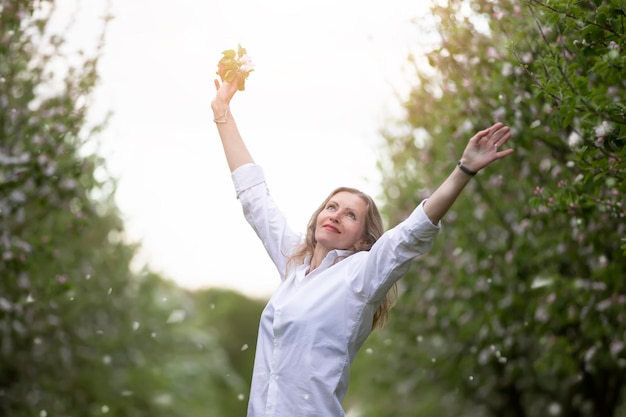 Schöne ältere Frau in einem blühenden Frühlingsgarten