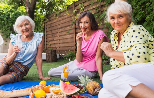 Schöne ältere Frauen, die sich zu Hause im Garten entspannen