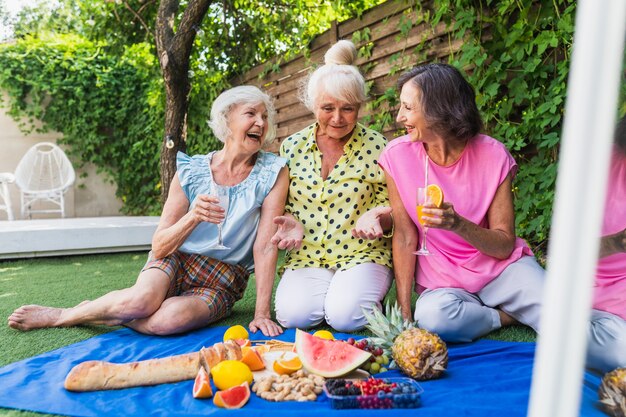 Schöne ältere Frauen, die sich zu Hause im Garten entspannen