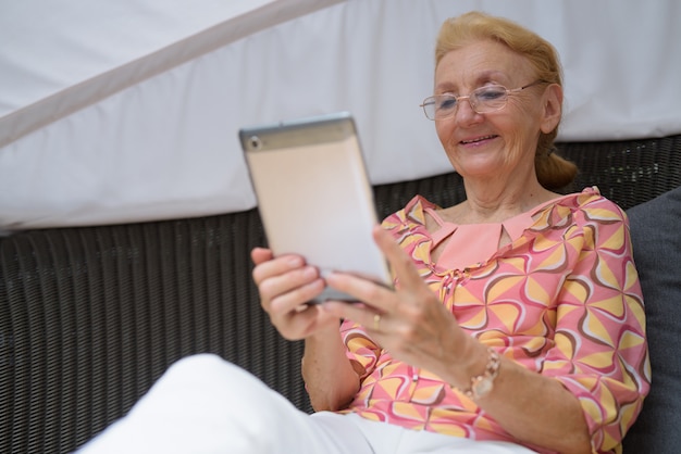 Schöne ältere Touristenfrau mit den blonden Haaren, die sich entspannen