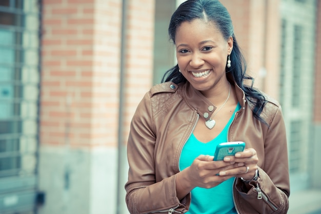 schöne afrikanische junge Frau mit Smartphone