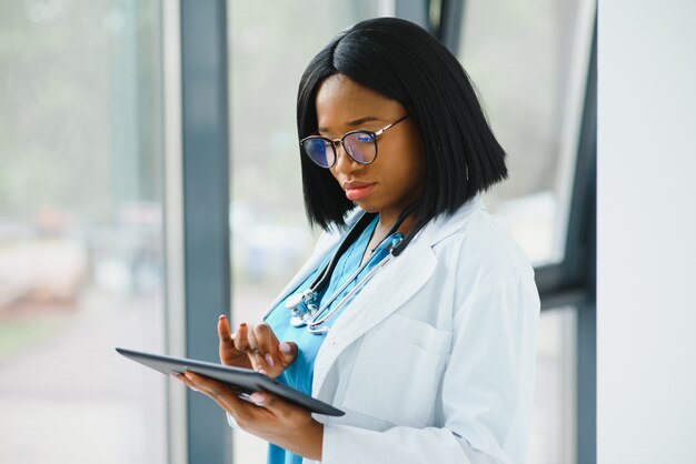 Schöne afroamerikanische weibliche Kinderkrankenschwester im modernen Büro