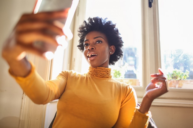 Schöne Afrofrau, die ein selfie nimmt