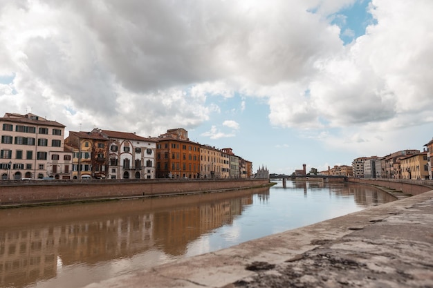 Schöne alte europäische Stadt mit alten Häusern entlang des Flusses auf einer Brücke in Pisa Italien