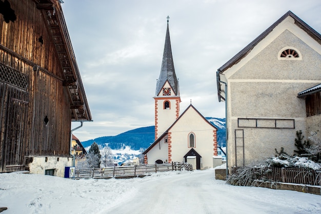 Schöne alte katholische Kirche in einer kleinen österreichischen Stadt mit Schnee bedeckt