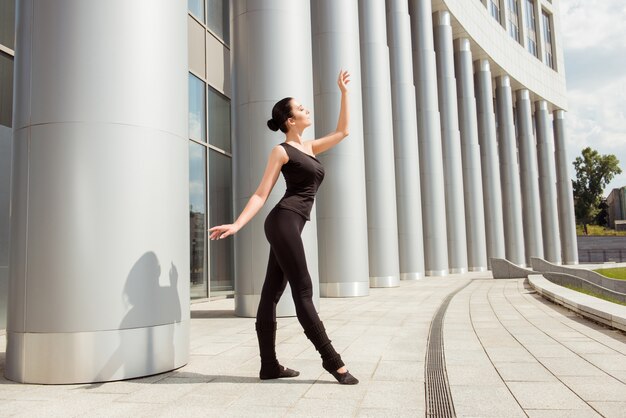 Schöne anmutige Ballerina, die in der Front des Gebäudes tanzt