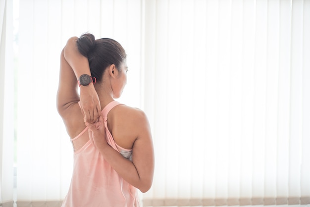 Schöne Asiatin trainieren mit Yoga in der Turnhalle.