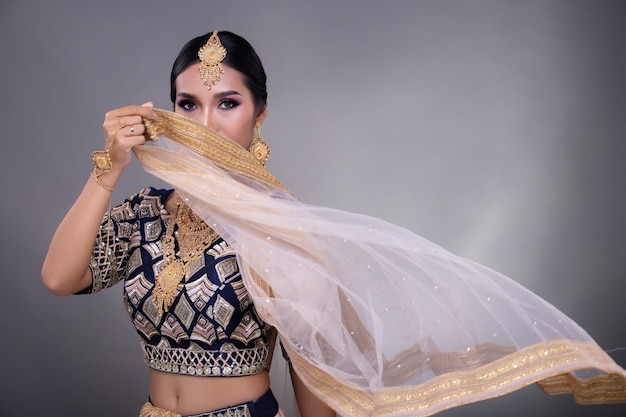 Schöne asiatische Frau, die im traditionellen Kleid mit Kopienraum aufwirft