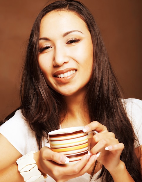 Schöne asiatische Frau, die Kaffee oder Tee trinkt
