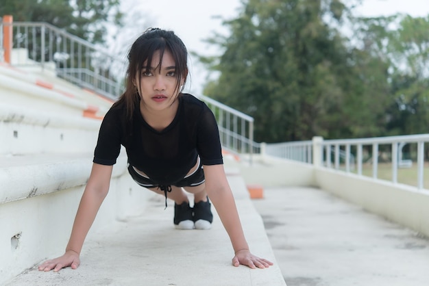 Schöne asiatische Frau, die Körper auf der Treppe ausdehnt