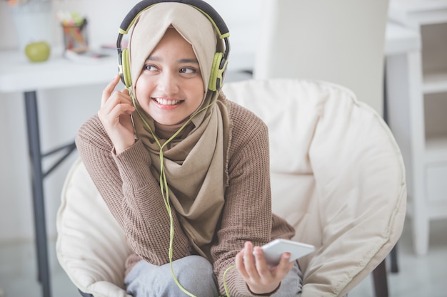 Schöne asiatische Frau, die Musik genießt