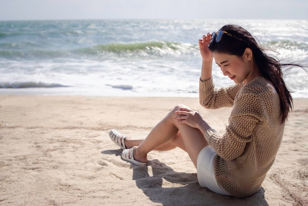 Schöne asiatische Frau entspannt sich am Strand