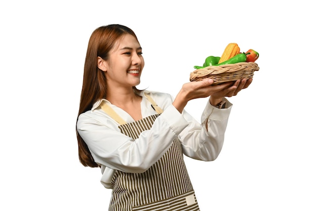 Schöne asiatische Frau hält einen Korb mit Gemüse im Hintergrund isoliert Gesundes Essen Konzept