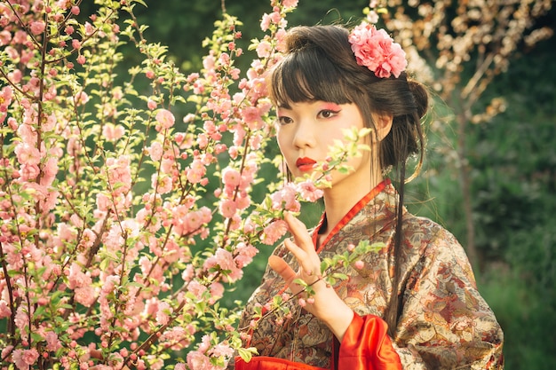 Schöne asiatische Frau in Sakura-Blüte