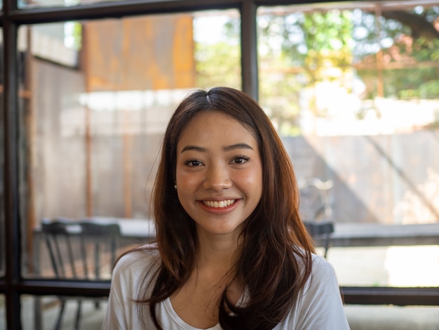 Schöne asiatische Frau lächelt in einem Café