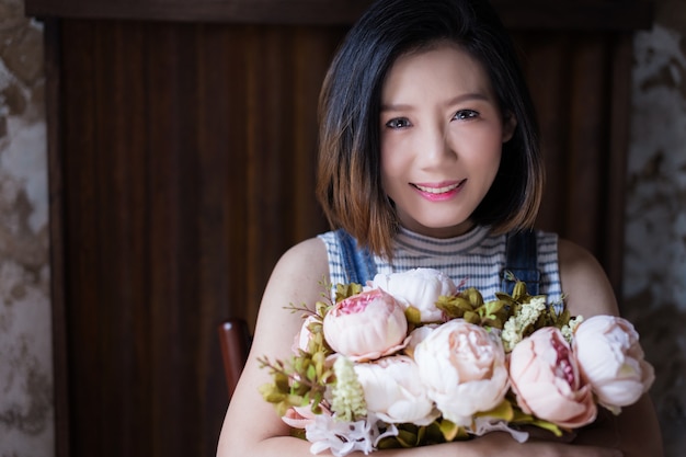 schöne asiatische Frau mit rosa Farbe der Blume in der Hand