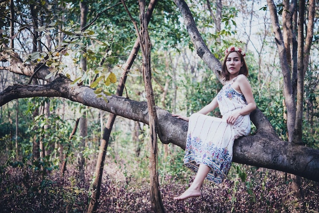 Schöne asiatische Frau trägt Kleid im Wald bei TageslichtThailand-Leute gehen in den Wald, um ein Foto zu machen