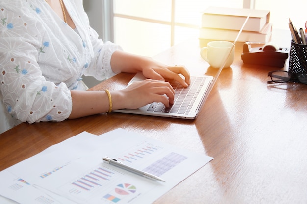 Foto schöne asiatische frauen analysieren dateninformationen mithilfe der quarantänezeit für technologie-laptops, die von zu hause aus arbeiten. glückliche freiberufler, die das haus nutzen, um ein kleines unternehmen zu gründen, das zu hause arbeitet