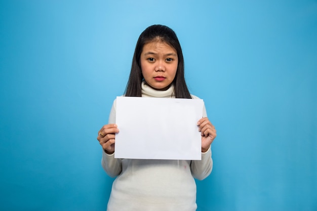 Schöne asiatische Frauen mit weißem T-Shirt mit blauem isoliertem Hintergrund Hände falten und verschroben