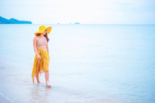 Schöne asiatische Frauen reisen im Sommer allein am Strand. Urlaub und Urlaub in Thailand.
