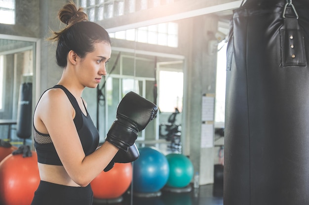 Schöne asiatische Frauenübung durch Boxen im Fitnessstudio oder Sportzentrum