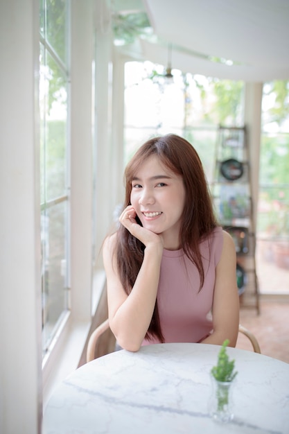 Schöne asiatische jüngere Frau, die sich entspannt und zahnig lächelt