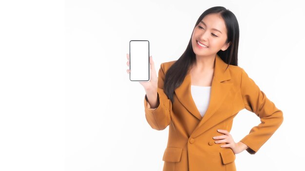 Schöne asiatische junge Frau. Aufgeregt überraschtes Mädchen zeigt Smartphone mit leerem Bildschirm, weißen Bildschirm für mobile App-Werbung, isoliert auf weißem Hintergrund, Smartphone-Display, Mock-up-Bild