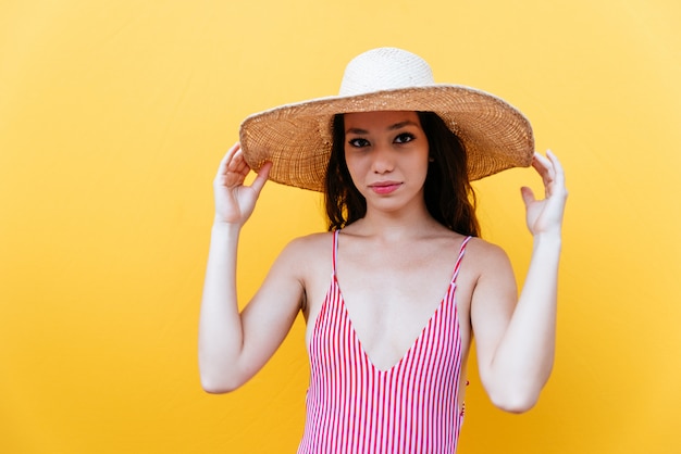 Schöne asiatische junge Frau mit Bikini. Porträts auf farbigem Hintergrund