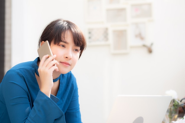 Schöne asiatische junge geschäftsfrau aufgeregt und froh über erfolgsarbeit mit laptop