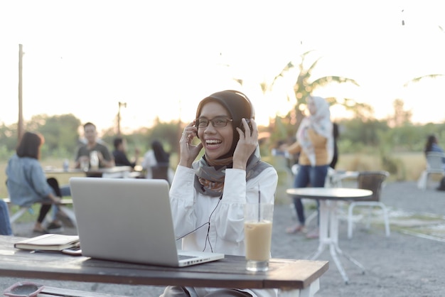 schöne asiatische muslimische dame freizeitkleidung, die mit laptop arbeitet