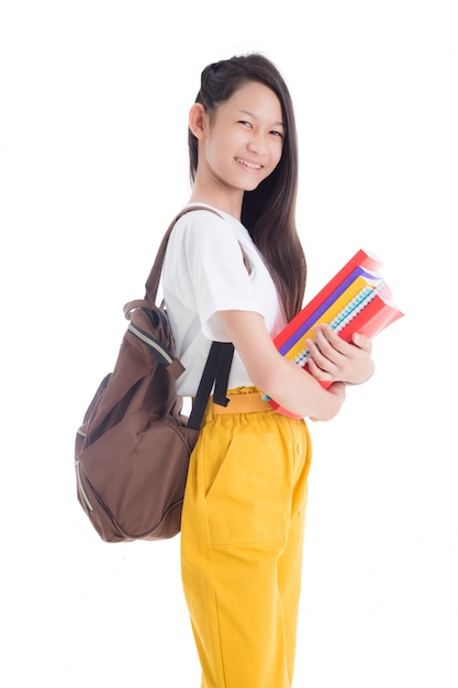 Schöne asiatische Teenager-Mädchen, die Bücher und Lächeln lokalisiert über weißem Hintergrund halten