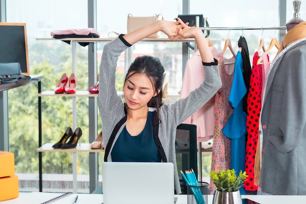 Schöne asiatische zufällige Frau ermüdete während des Arbeitsstart-Kleinunternehmers KMU im Kleidungsshop.