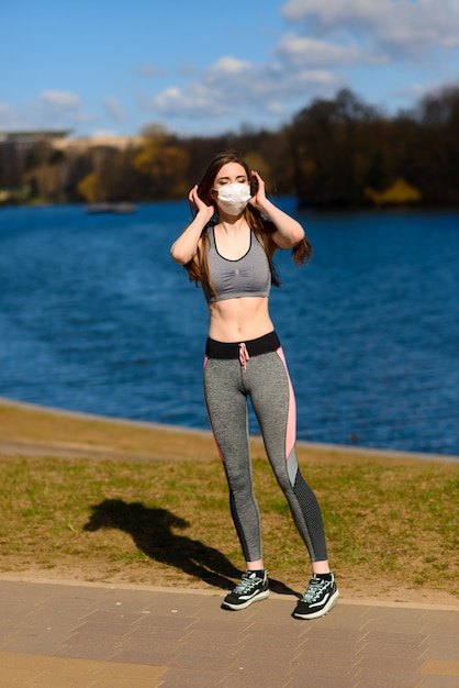 Schöne athletische Frau mit einer Maske im Park