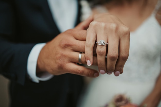 Schöne Aufnahme der Hände einer Braut und eines Bräutigams, die ihre Ringe zeigen - Hochzeit, Jubiläum