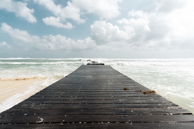 Schöne Aufnahme einer Holzstraße zum Meer oder zur Meeresküste bei bewölktem Himmel