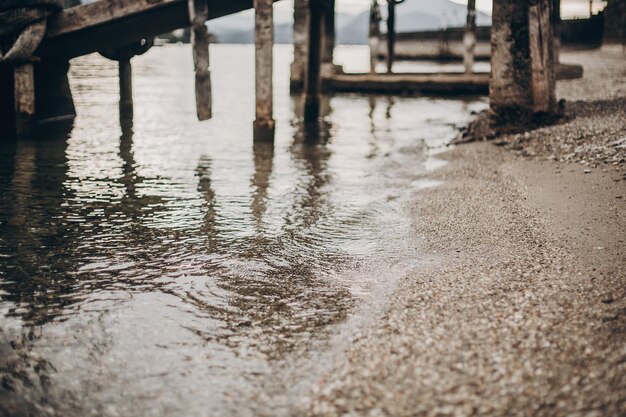 Schöne Aussicht auf altes Dock und Wasser mit Steinen am Strand von Lago Maggiore Stresa Stadt Italien Pier am Lago Maggiore Sommerurlaub in Europa