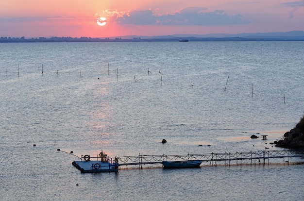 Schöne Aussicht auf den Sonnenuntergang am Meer mit Sonne, Sonnenspur und Pier.