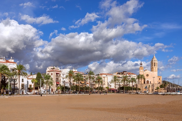 Schöne Aussicht auf die berühmte Promenade von Sitges mit der Kirche Sant Bartomeu und Santa Tecla unter dem schönen Himmel