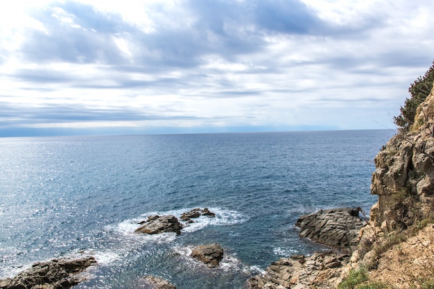 Schöne Aussicht auf die Meereswellen, Felsen, Steine und Wolken am Himmel.