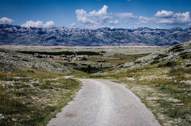 Schöne Aussicht auf eine Straße, umgeben von felsigen Bergen bei bewölktem Himmel