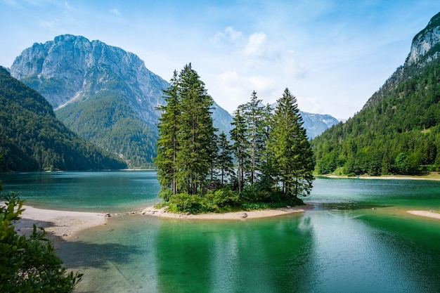 Schöne Aussicht auf einen See, umgeben von felsigen Bergen und viel Grün in Italien