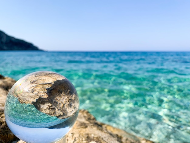 Schöne Aussicht durch die Linse der Kristallkugel auf dem Wasser Selektiver Fokus