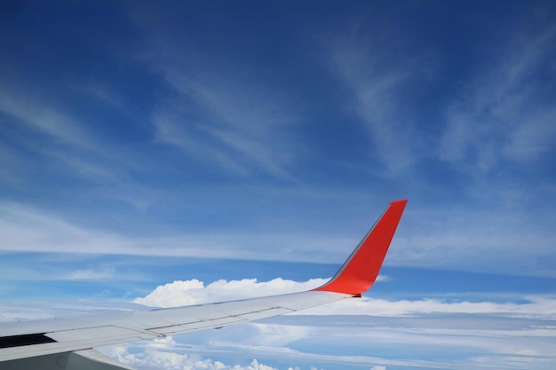 Schöne Aussicht vom Flugzeugfenster mit blauem Himmel des Flugzeugflügels und weißer Wolke im Sommer